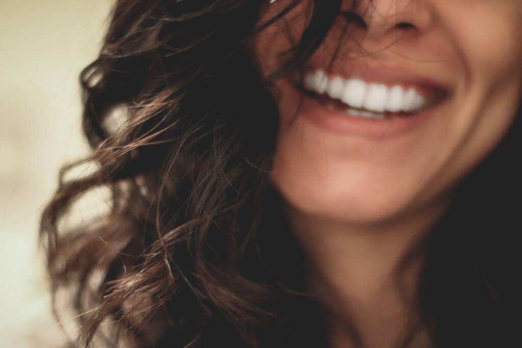 mulher de cabelos pretos compridos sorrindo fotografia em close-up