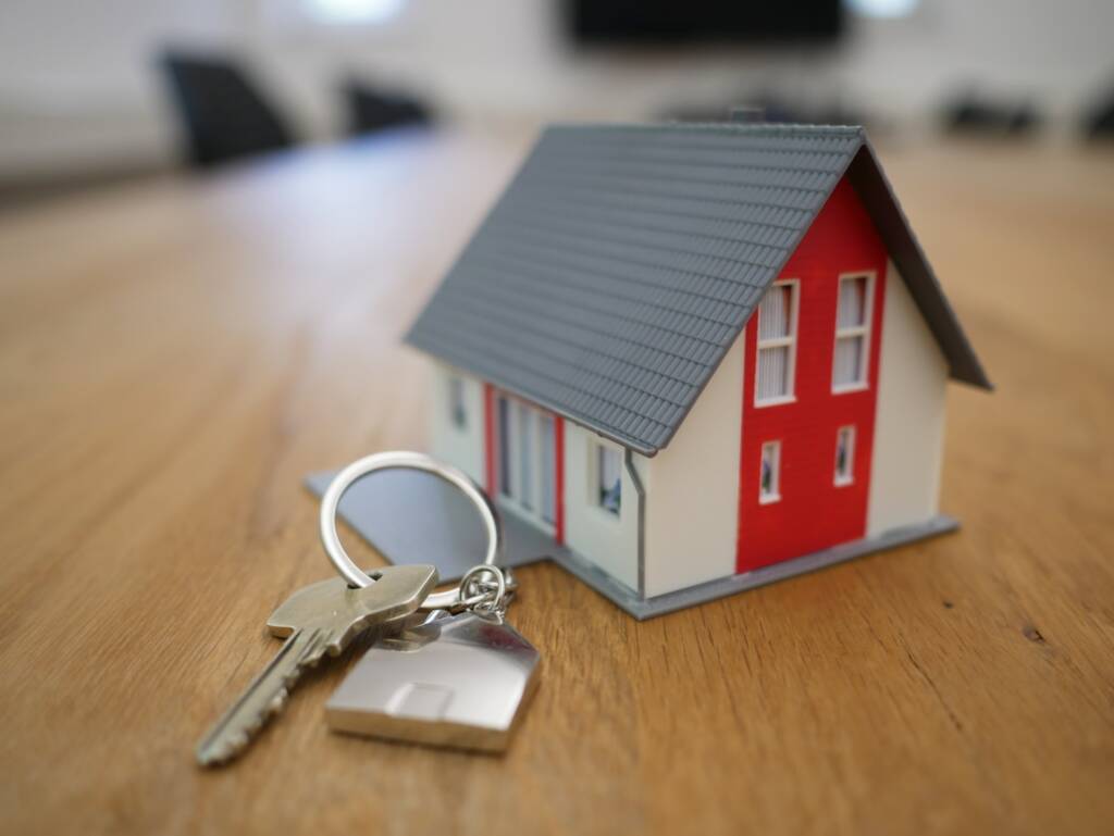 miniatura de casa de madeira branca e vermelha na mesa marrom